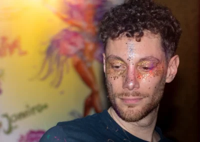 Homme au visage couvert de paillettes colorées