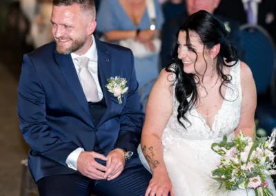 Couple de mariés souriants assis pendant la cérémonie